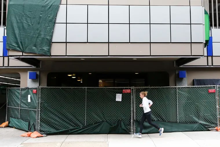 A jogger passes by the street entrance of the Holiday Inn Express in Center City on Sunday, April 5, 2020, after the city rented out the hotel for use as a quarantine site.