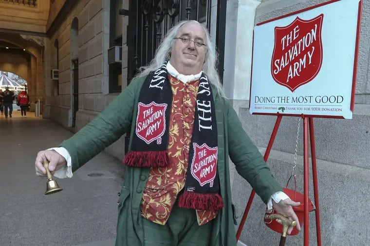 Ben Franklin impersonator Robert DeVitis slips into character to ring the Salvation Army kettle bell outside City Hall.