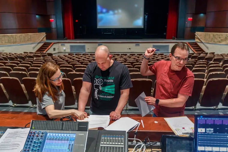 Jill Feldman, executive director of the Greenfield Film Festval, Dave Thomas, the host and educational director of the festival, and Carl Woodin (right), the festival coordinator, prepare for the event in the Center for Performing Arts at Upper Dublin High School.