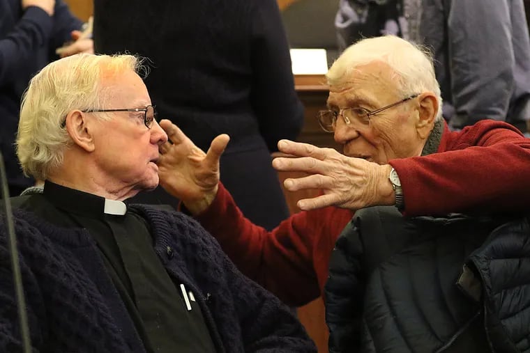 The Rev. Michael Doyle (left) and Eugene Dixon, former members of the group of Vietnam war protesters known as the Camden 28, reunite Dec. 6 in a Camden courtroom.
