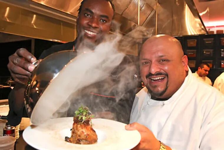 Sylva Senat, Executive Chef (left), and Sanjay Shende, Indian Master Chef, lift the lid of their Quail dish. (Steven M. Falk / Staff Photographer)