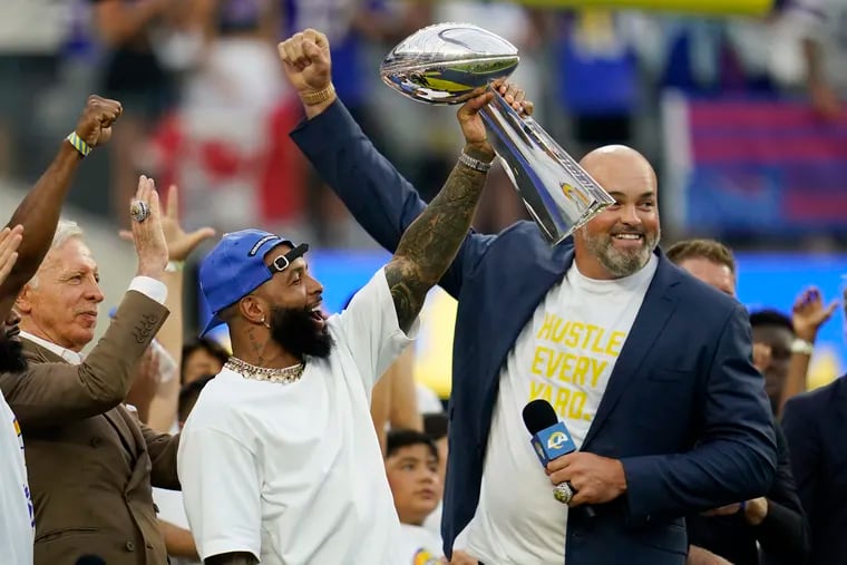 Former Los Angeles Rams wide receiver Odell Beckham Jr. (center) lifts the 2021 championship trophy next to ex-player Andrew Whitworth (right) and team owner Stan Kroenke before a game against the Buffalo Bills on Sept. 8.