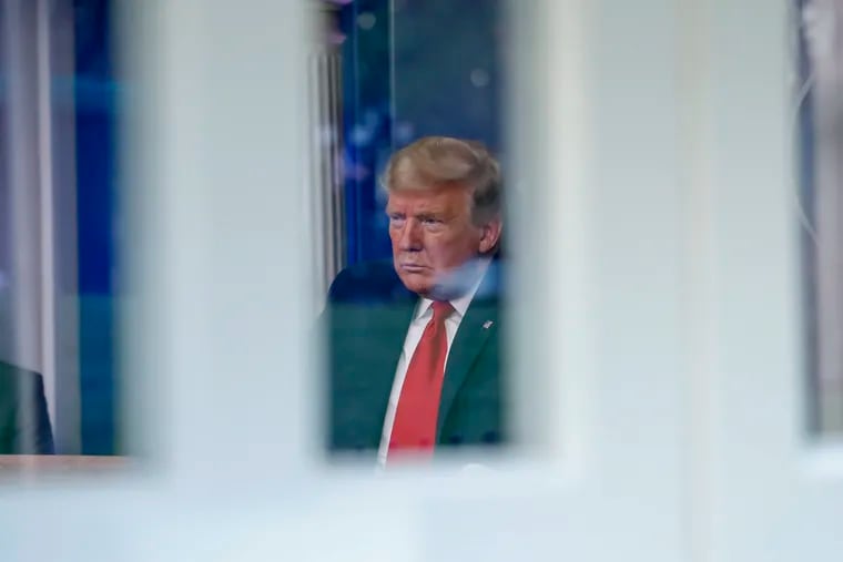 Seen through a window, President Trump spoke about the coronavirus in the James Brady Briefing Room on Thursday.