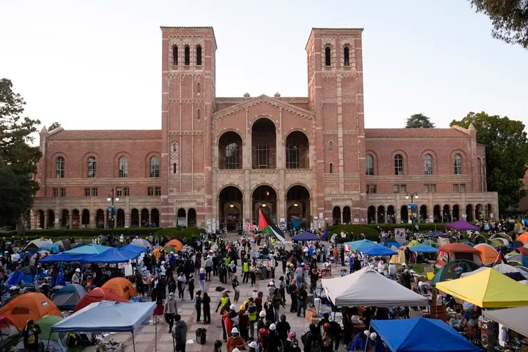 Demonstrators walk in an encampment on the UCLA campus, the morning after clashes between pro-Israel and pro-Palestinian groups, Wednesday in Los Angeles.