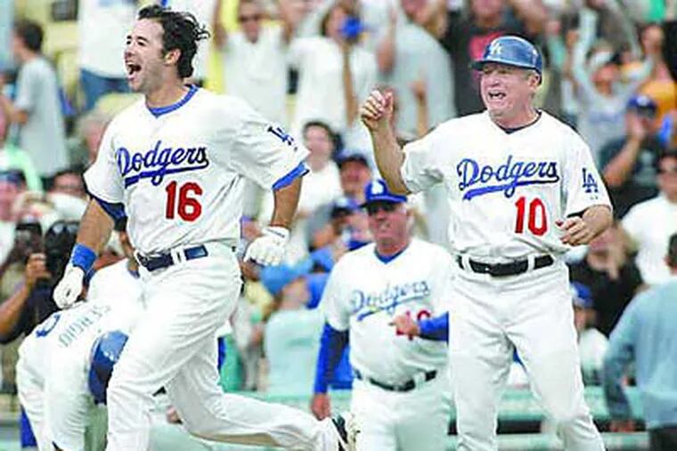 Dodgers' Larry Bowa (right), who spent four years as the Phillies manager, celebrates as Andre Ethier scores a game-winning run over the Phillies back in June. (Associated Press)