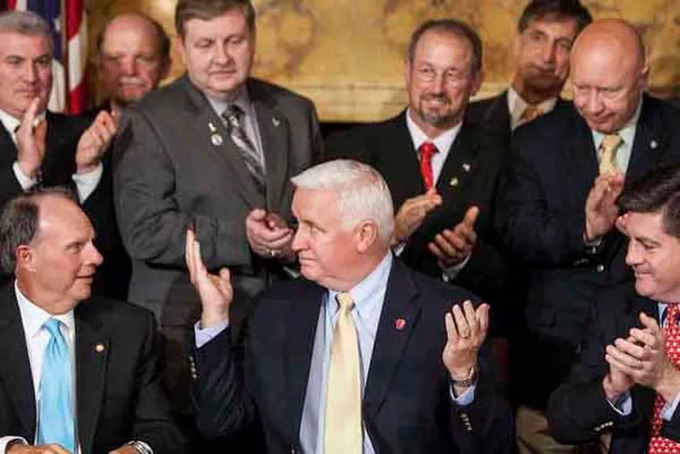 In this June 30, 2013 photo,  Pennsylvania Gov. Tom Corbett, surrounded by House Republicans, reacts after signing the 2013-14 state budget after the House approved the Senate-passed budget in Harrisburg, Pa. At left is House Appropriations Committee Chairman Rep. William Adolph, R-Delaware County, and at right is Lt. Gov. Jim Cawley. (AP Photo/The Patriot-News, Dan Gleiter)