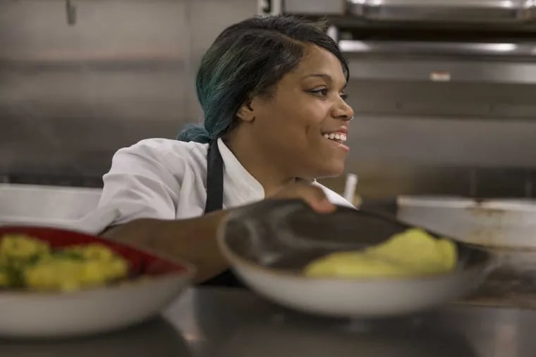 Markeeta Henderson, line cook at Broad Table Tavern in Swarthmore, PA, is all smiles as she talks to her fellow line cook, Chris Campbell, as she places her completed dish up on the shelf to be picked up by a server and taken to the table during Sunday brunch. Uplifting story of Markeeta Henderson from Germantown, who gets up at 2:30 a.m to get to her 5:30 a.m. job as a line cook at Broad Table Tavern in Swarthmore. She pulled herself up from poverty through Philabundance culinary program for at-risk Philadelphians.