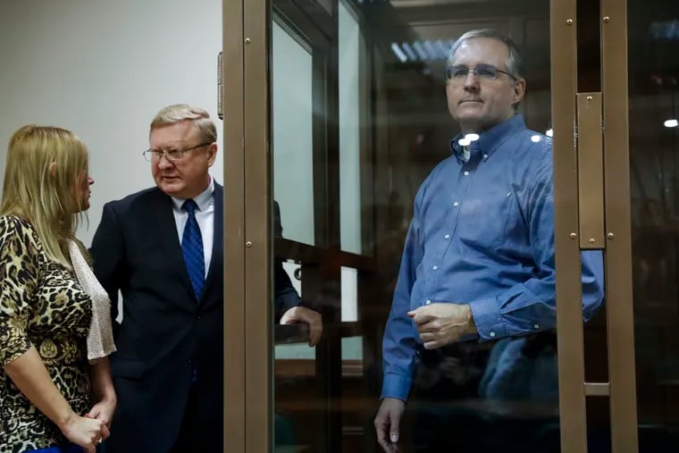 Paul Whelan, a former U.S. Marine, who was arrested in Moscow at the end of last year, right, looks through a cage's glass as his lawyers talk to each other in a court room in Moscow, Russia, Tuesday, Jan. 22, 2019.