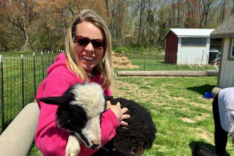Amanda Coombs Shimp, who owns a family farm in Salem County, NJ, with a lamb named Gracie.