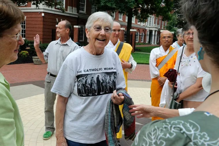 In this Aug. 9, 2012 photo, Sister Megan Rice, center, and Michael Walli, in the background waving, were greeted by supporters as they arrived for a federal court appearance in Knoxville, Tenn., after being charged with sabotaging a government nuclear complex.