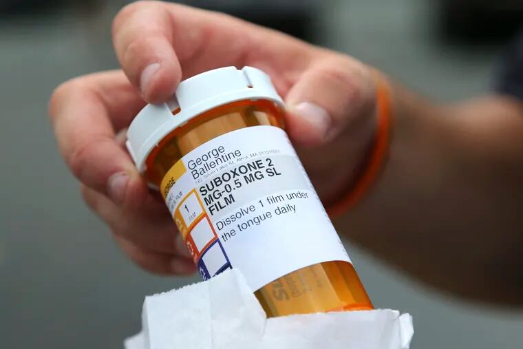 A man holds his prescription medicine Suboxone outside a pharmacy in Greenfield, Mass. last year.