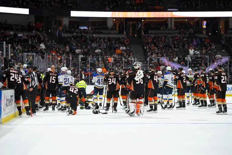 Members of the St. Louis Blues and Anaheim Ducks gather on the ice as Blues defenseman Jay Bouwmeester, who suffered a medical emergency, is worked on by medical personnel during the first period.