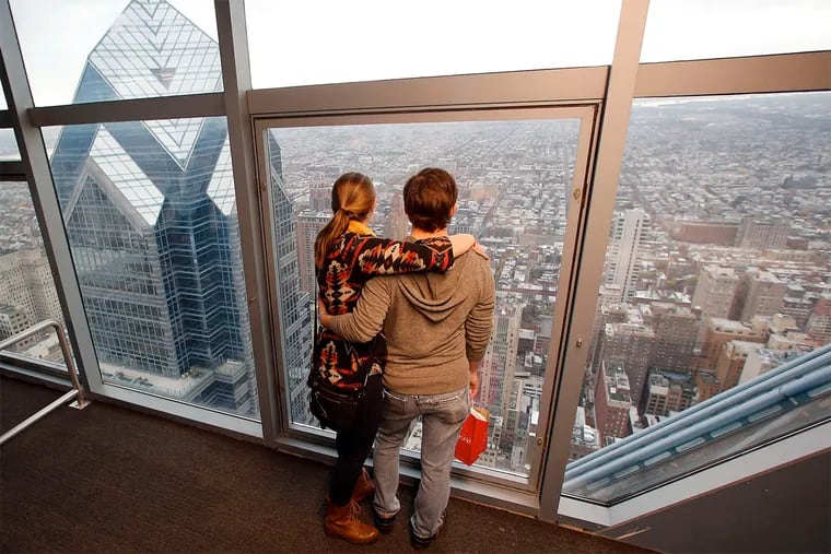 Rachel Reeves and Brian Turner look toward South Philadelphia from the 57th floor of One Liberty Place. One Liberty Observation Deck, which opened to the public Saturday, offers sweeping views of the city and beyond. Story, B1.