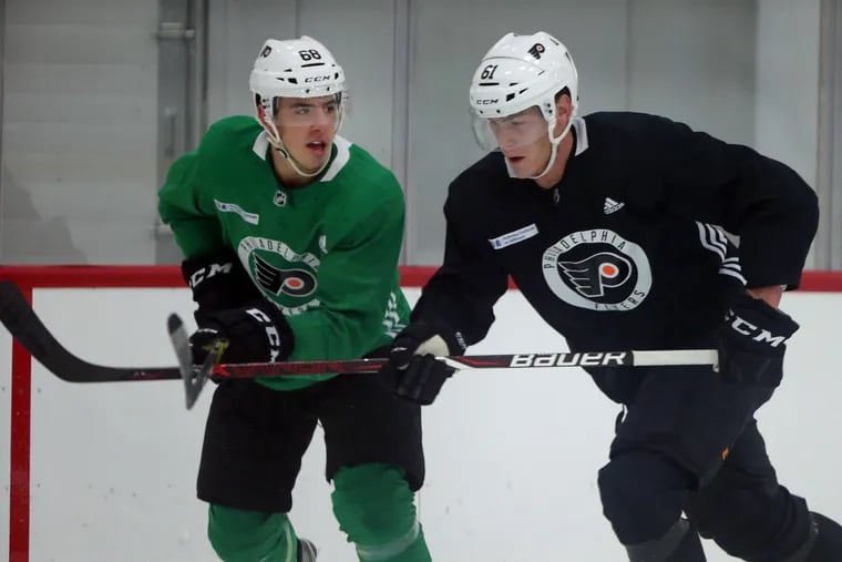 Center Morgan Frost (left) and defenseman  Phil Myers take part in a drill during the Flyers' rookie camp Monday.