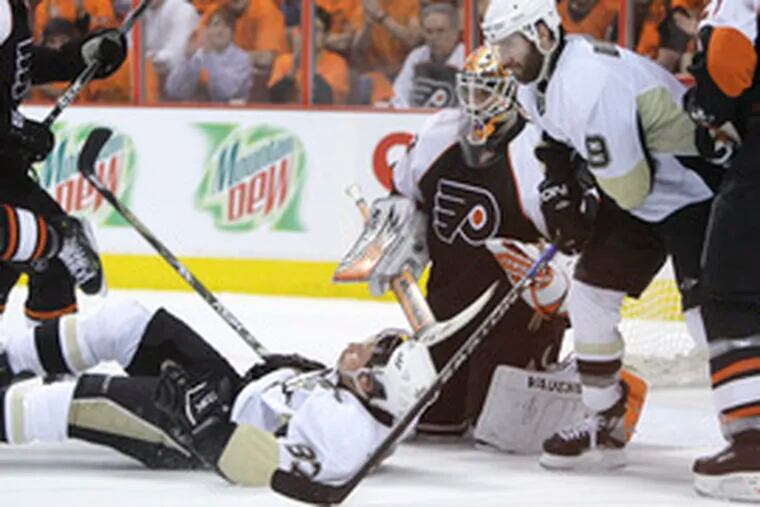 The Penguins&#0039; Sidney Crosby is taken down in front of teammate Pascal Dupuis and Flyers goalie Marty Biron during a power play.