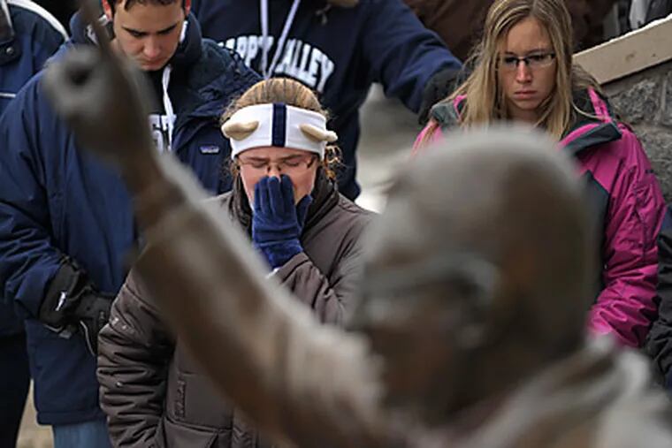 Penn State students can't hold back their emotions as they gather around the statue of Joe Paterno. (Photo by Nabil K. Mark)
