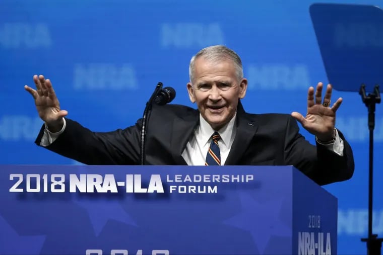 Former U.S. Marine Lt. Col. Oliver North acknowledges attendees as he gives the Invocation at the National Rifle Association-Institute for Legislative Action Leadership Forum in Dallas on Friday.