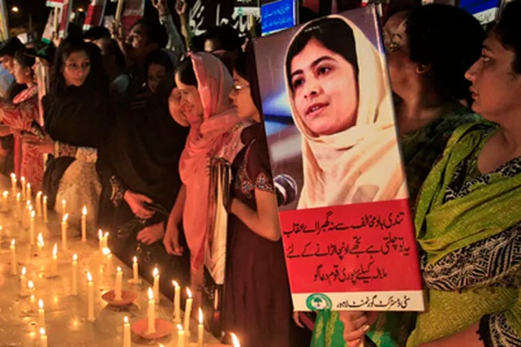 A woman holds a poster of Malala Yousufzai during a candlelight vigil in Lahore, Pakistan. AP