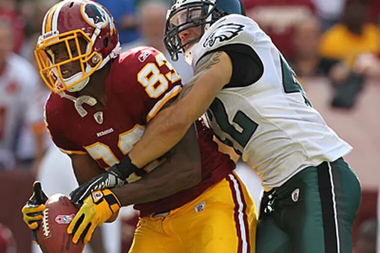 Safety Kurt Coleman, right, strips the ball out of Redskins wideout Fred Davis' hands to negate a big play. (Michael Bryant/Staff Photographer)