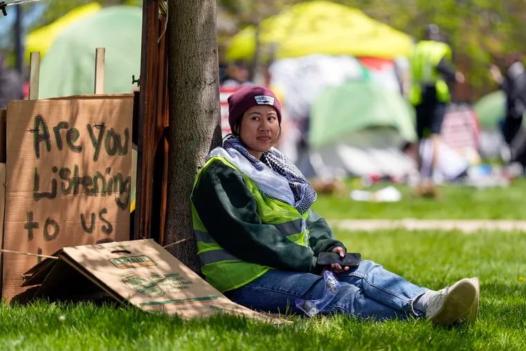 A woman sits outside an encampment area on the University of Wisconsin-Milwaukee campus.