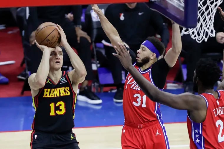 Hawks guard Bogdan Bogdanovic shoots as Sixers guard Seth Curry and center Joel Embiid defend in the fourth quarter of Game 1 of the Eastern Conference semifinals.