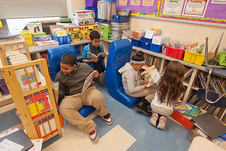Fourth grade students in Elizabeth Rodriguez's class at Catto Community school in Camden look over books in the the reading area Rodriguez would enhance if she were to receive funding from DonorsChoose on Feb. 5, 2014. ( RON TARVER / Staff Photographer )