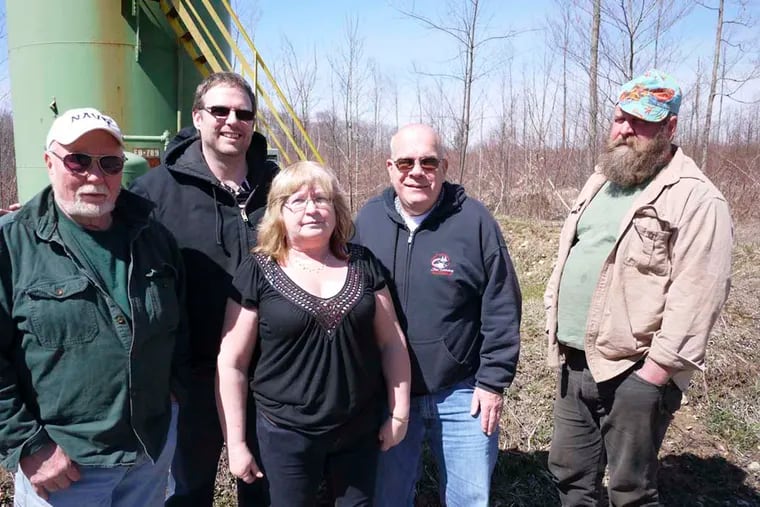 Activists who have led the fight against Seneca — (from left) Cliff Stump, John Guras, Marsha Buhl, Mike Kamandulis, and Tim Garity — gather outside the existing natural gas well.