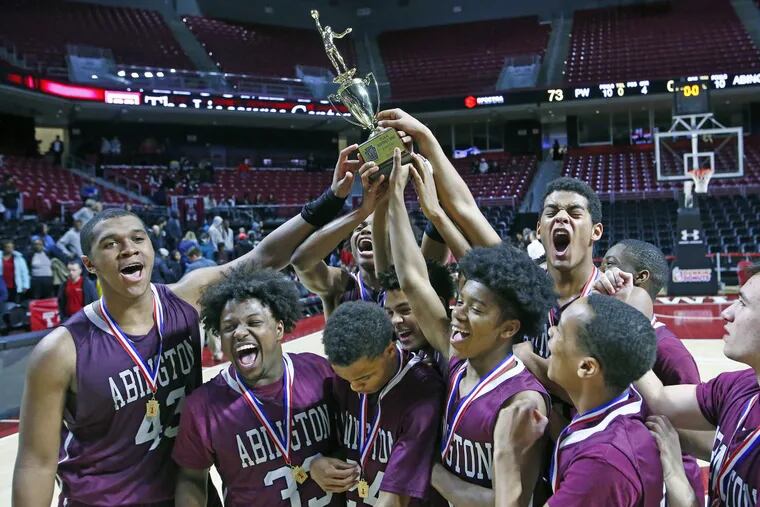 Abington players celebrate with the trophy after winning the District 1 Class 6A championship with a 75-73 victory over Plymouth Whitemarsh.
