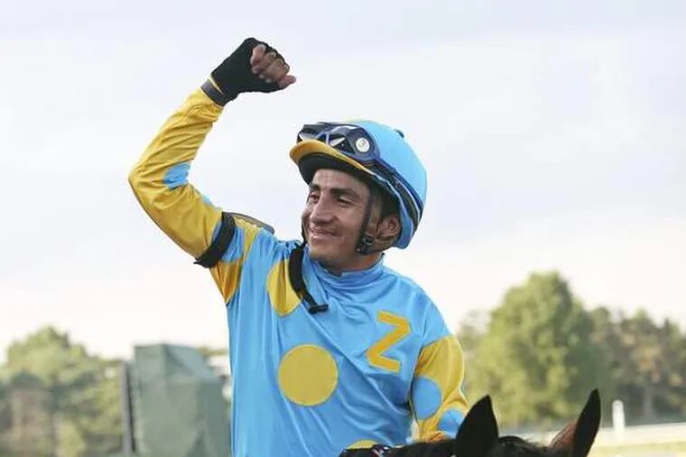 In this photo provided by EQUI-PHOTO, jockey Rafael Bejarano raises his fist in victory after guiding Paynter to win the $1 million Haskell Invitational horse race, Sunday, July 29, 2012, at Monmouth Park in Oceanport, N.J. (AP Photo/EQUI-PHOTO, Mark Wyville)