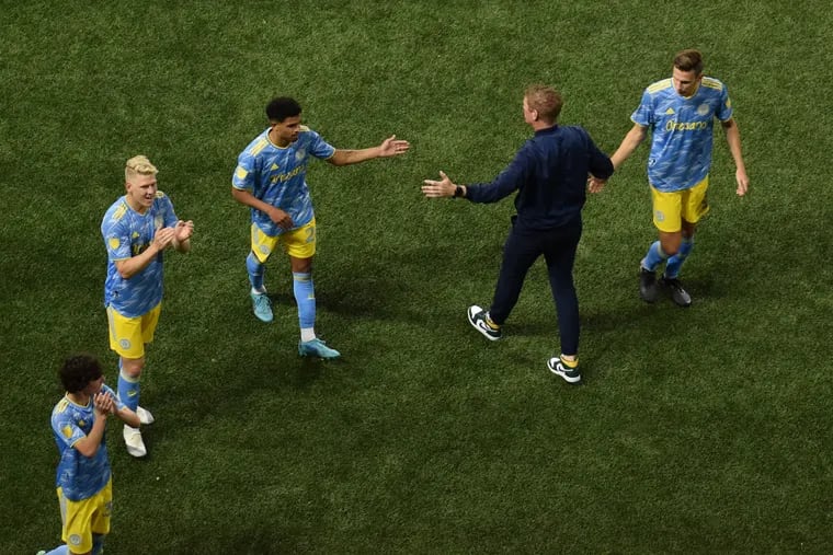 Jim Curtin (second from right) shakes hands with Jack Elliott (right) and Nathan Harriel (center) as Paxten Aaronson (left) and Jakob Glesnes (second from left) applaud the visiting fans after the Union's 2-0 win at the Portland Timbers.