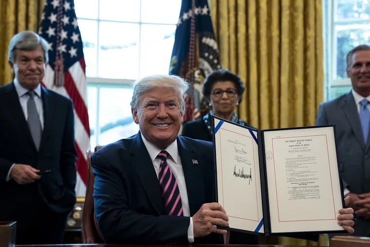 President Donald Trump smiles holding up his signed H.R.266, the first Paycheck Protection Program and Health Care Enhancement bill, in the Oval Office of the White House in Washington DC on April 24th, 2020. (Pool/Abaca Press/TNS)