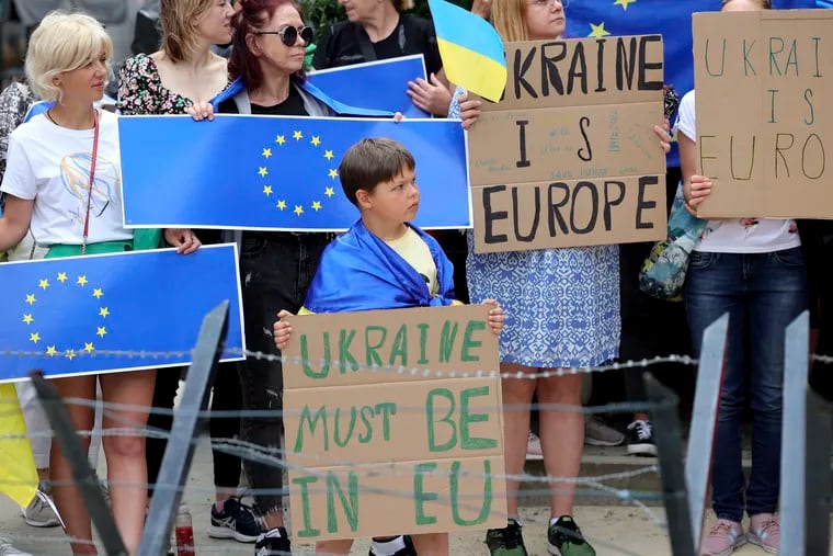 Protestors in support of Ukraine stand with signs and E.U. flags during a demonstration outside of an E.U. summit in Brussels on Thursday.