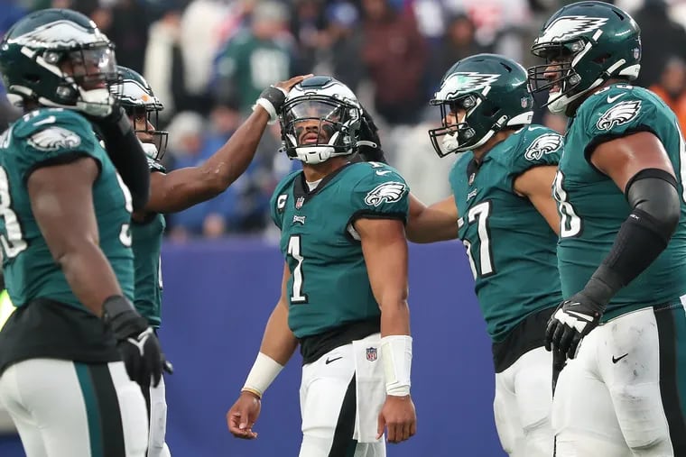 Philadelphia Eagles quarterback Jalen Hurts (center) is consoled by free safety Anthony Harris (left) and T.J. Edwards (right) after the Eagles last offensive drive of the game against the Giants. The Eagles lose 13-7 to the Giants at MetLife Stadium in East Rutherford, New Jersey on Sunday, Nov. 28, 2021.