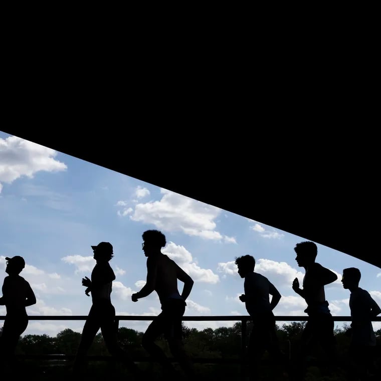 Runners move along the Schyulkill River Trail under the Girard Avenue Bridge in Philadelphia.