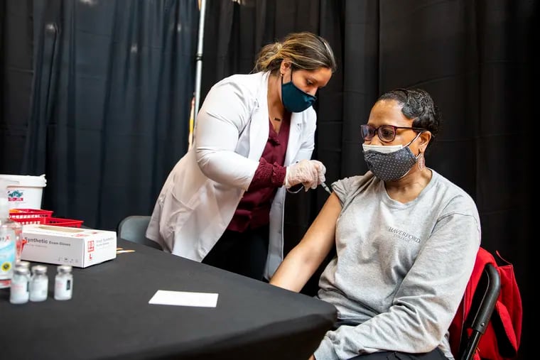 Kim Kulick, pharmacist at Rite Aid, gives the vaccine shot to Concetta White, 56, housekeeper at Haverford College, during a clinic last week.