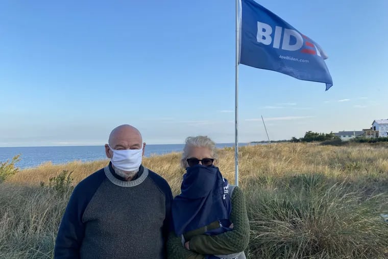 In Slaughter Beach, Del., Bill Wernick, left, and neighbor Roxana Moayedi, in front of the Biden flag they have planted along the Delaware Bay coast in front of their houses. "I think he would bring back the ideal of America that I came to this country for from Iran," Moayedi said.