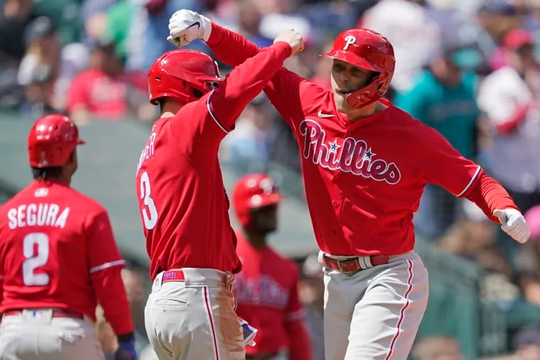 The Phillies' Rhys Hoskins (right) is greeted by Bryce Harper at the plate after Hoskins hit a grand slam against the Seattle Mariners.