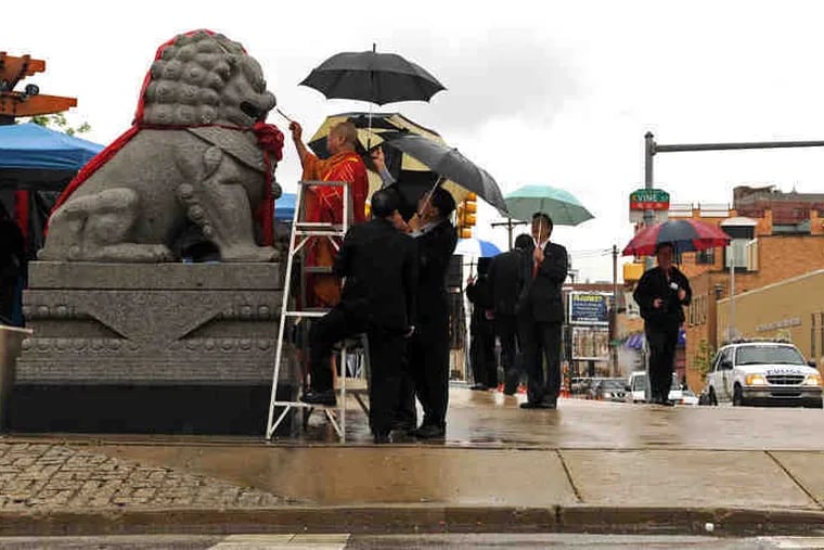 Buddhist monk Thich Truyen Nhu of Temple Chua Quan Am at 12th Street and Ridge Avenue blesses the Foo Dog statues - Chinese guardian lions - before dedication ceremonies Wednesday of the renovated 10th Street Plaza at 10th and Vine Streets in Chinatown. Story and photos on B2.