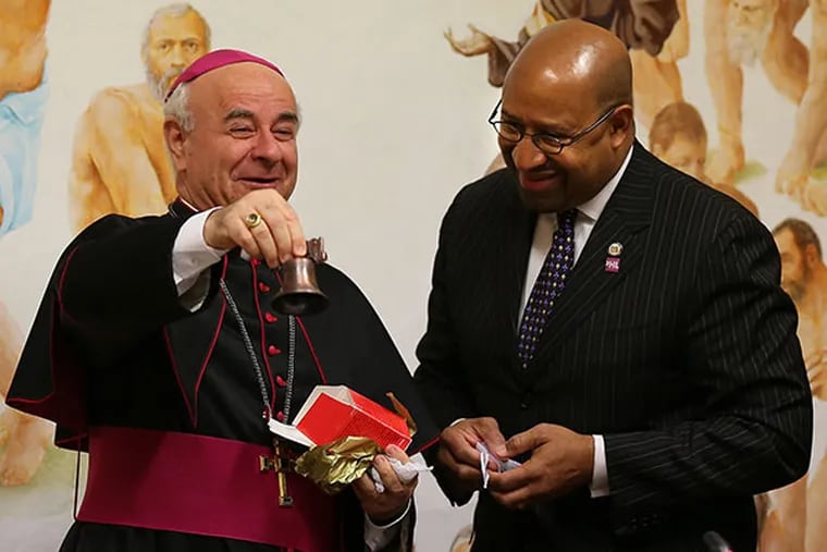 Archbishop Vincenzo Paglia, left, the President of the Holy See's Pontifical Council for the Family, rings a souvenir Liberty Bell, a gift from Mayor Michael Nutter, right, during their meeting at Pontifical Council for the Family in Rome, Italy on March 25, 2014.  ( DAVID MAIALETTI / Staff Photographer )