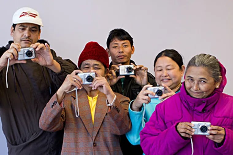 Bhutanese immigrants like Karna Karki (far left) use photo therapy as a way to manage a new language and culture and to form a new community in the U.S. DAVID M WARREN / Staff Photographer