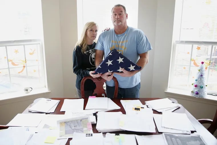 Charles Strange, right, and his wife, Mary Ann, stand for a portrait with a memorial flag at their home in Hatboro. Their son, Michael, a U.S. Navy cryptologist, was killed in action in Afghanistan in 2011.