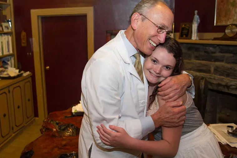 Sherman Leis, who performed Aly Bradley's sex reassigment surgery at Lower Bucks Hospital in Bristol, gives her a hug in his office.