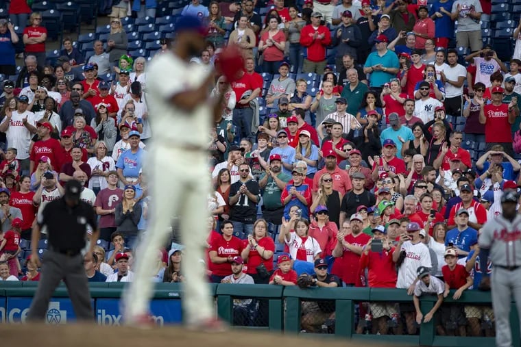 Fans cheer as relief pitcher Seranthony Dominguez prepares to throw the final pitch of the 2018 Phillies season.