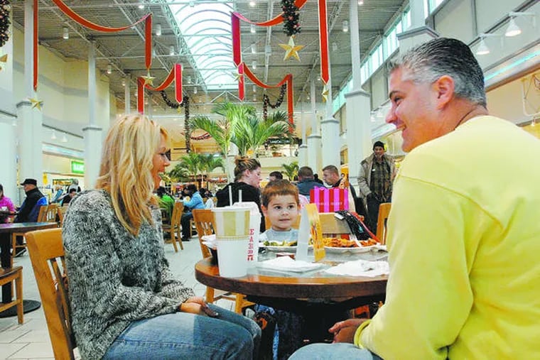 The Grady family of Mount Ephraim - parents B.J. and Bill and 4-year-old Charlie - relax in the food court of the Voorhees Town Center, a mixed-use project intended to rejuvenate the former Echelon Mall.