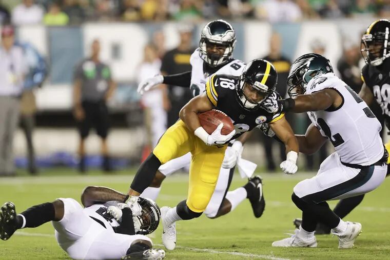 Eagles defensive back Jeremy Reaves (left) and linebacker Corey Nelson stop Pittsburgh Steelers punt returner Justin Thomas during a preseason game on Thursday, August 9, 2018 in Philadelphia. YONG KIM / Staff Photographer