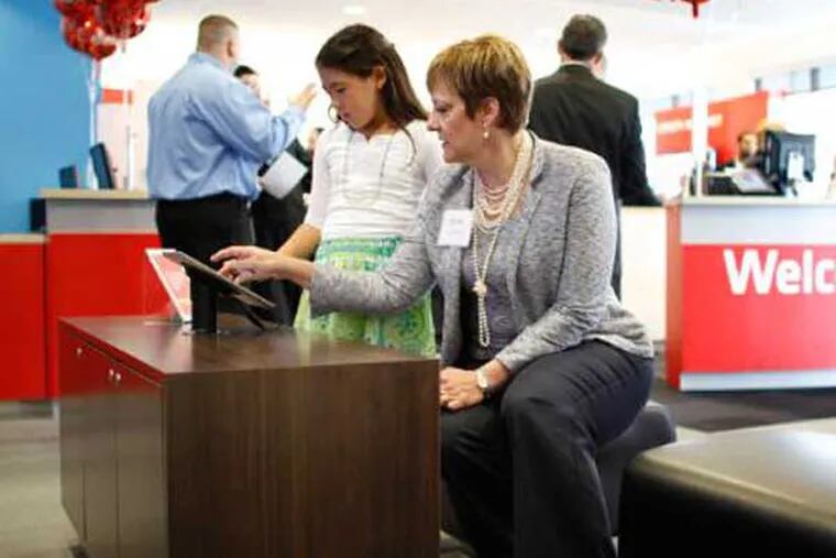 Comcast Regional Senior Vice President LeAnn Talbot demonstrates an Xfinity iPad app to Allison Goodman, 10, at the opening of the new Xfinity store in the Oxford Valley Plaza in Langhorne Pa., on Thursday April 26, 2012. (Comcast Photo / Joseph Kaczmarek)
