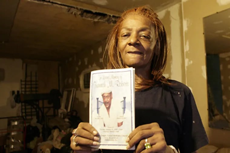 Rhonda Wearing of South Philadelphia holding a program from her father’s funeral. Another man’s body replaced Kenneth Roberts in the casket. (Yong Kim / Staff Photographer)