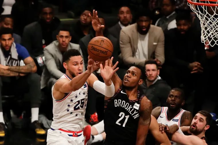 Sixers guard Ben Simmons passes the basketball past Brooklyn Nets guard Treveon Graham during the second-quarter in game three of the Eastern Conference playoffs on Thursday in Brooklyn.