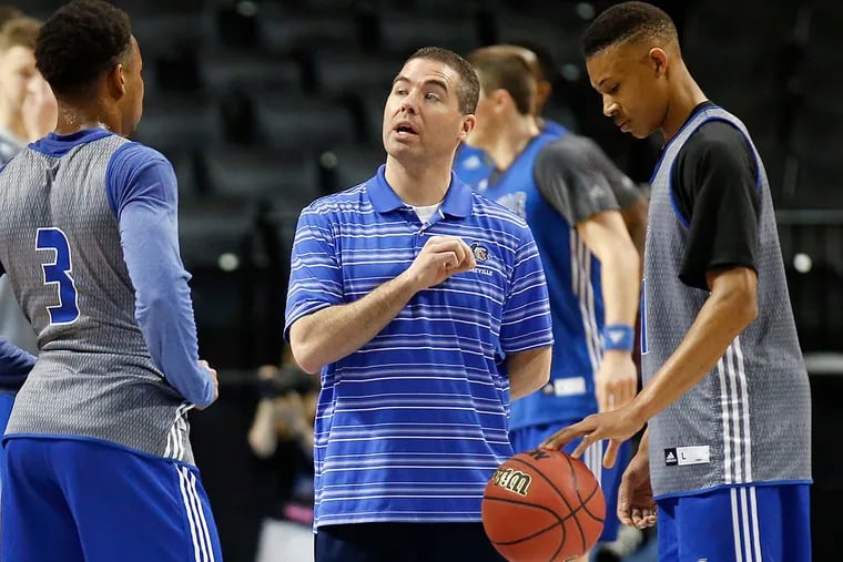 UNC-Asheville coach Nick McDevitt (center) talks to players Trae Bryant (left) and Raekwon Miller during practice at the Barclays Center in Brooklyn on Thursday, March 17, 2016.