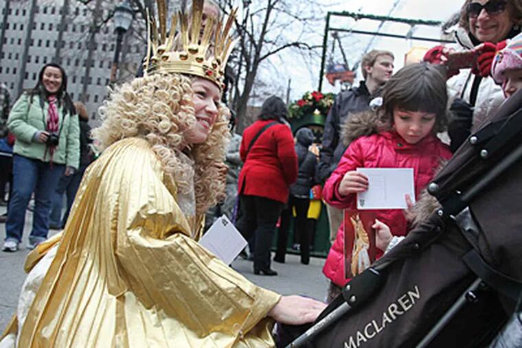 In Germany and other parts of the world, the traditional gift-bearer is Christkind, who handed out postcards to children Saturday. RYAN S. GREENBERG / Staff Photographer